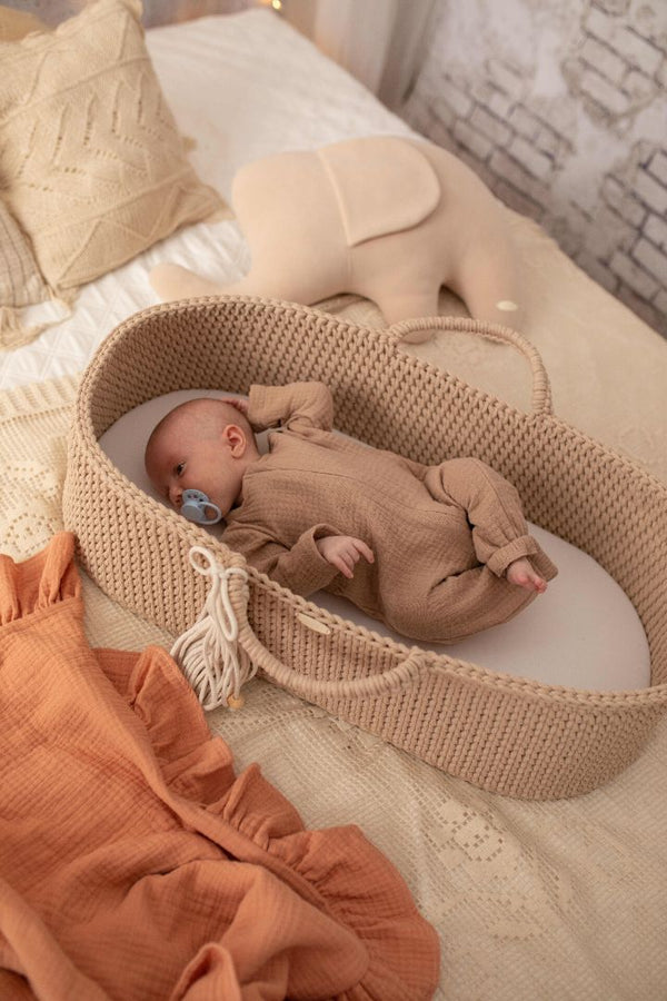Baby in handmade crochet moses basket in latte from The Baby Den