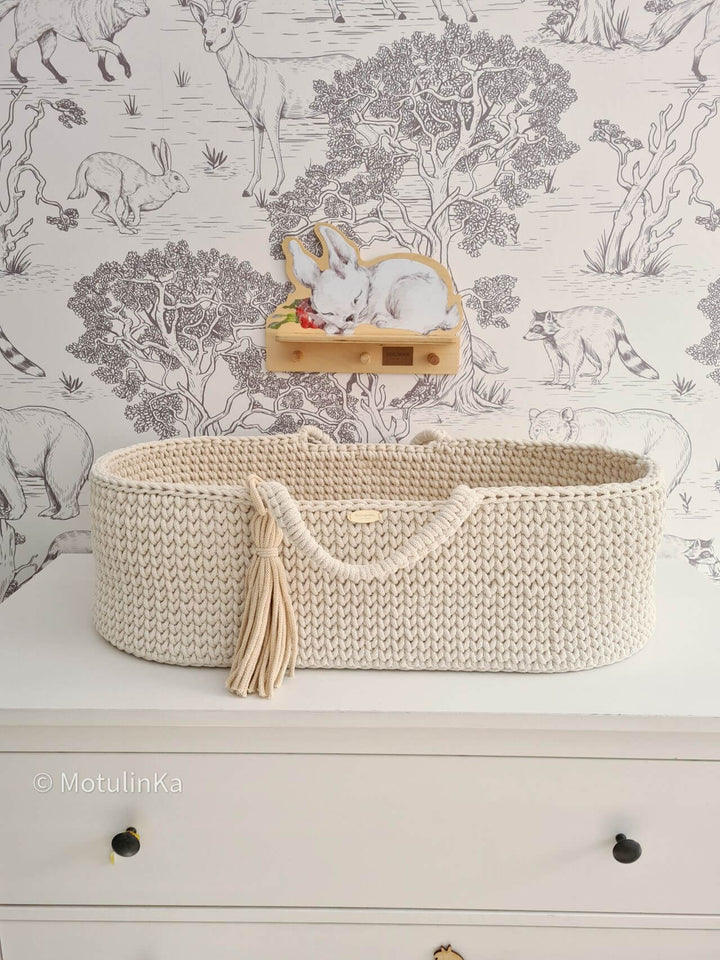 Cream handmade crochet moses basket displayed on a chest of drawers