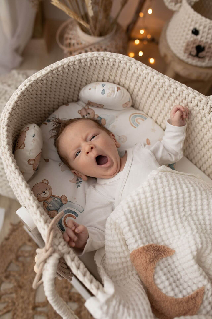 Baby boy in a cream handmade crochet moses basket from The Baby Den