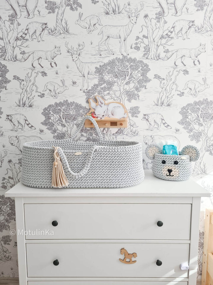 Grey handmade crochet moses basket with a matching grey crochet storage basket for nursery