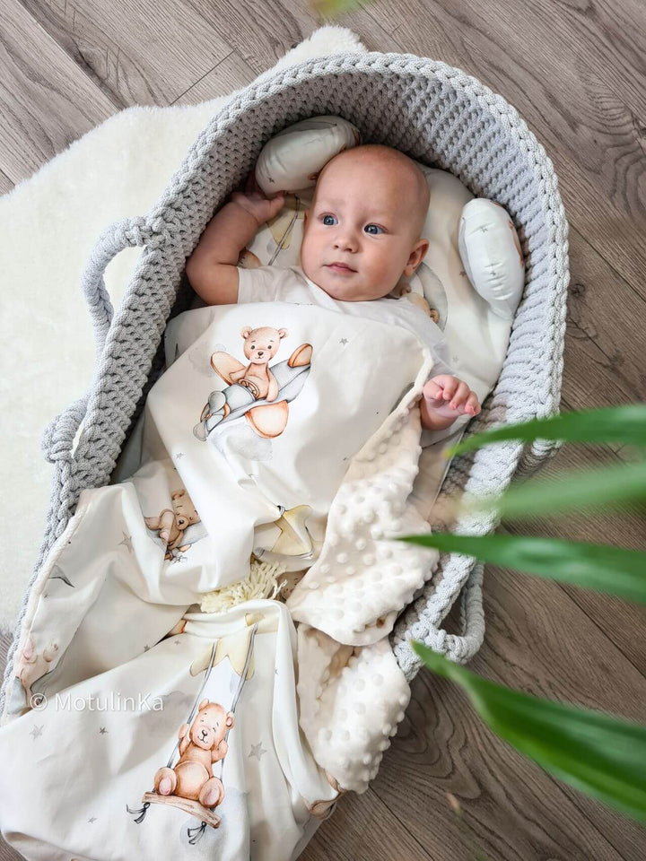 Baby boy in a grey handmade crochet moses basket